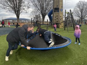 adult and child playing on playground equipment