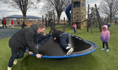 adult and child playing on playground equipment
