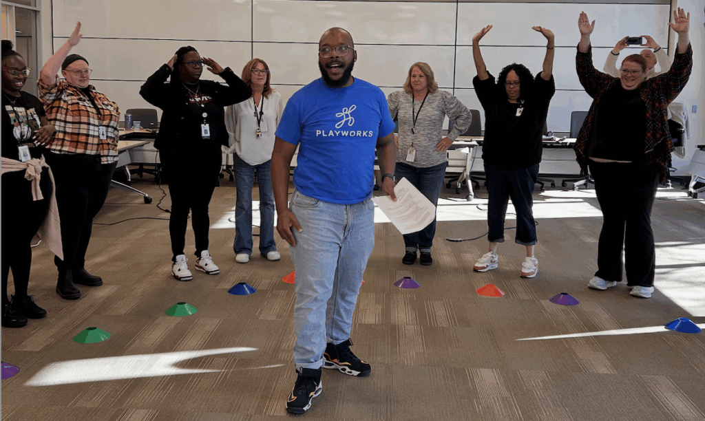Playworks staff leading adults in game