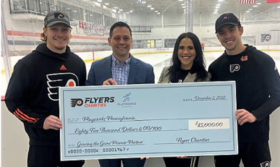 Playworks and Flyers staff with check