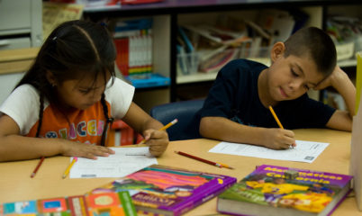 two students writing on worksheets