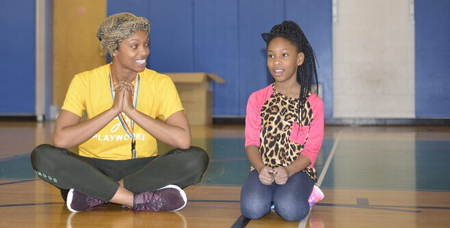 woman and child sitting on gym floor