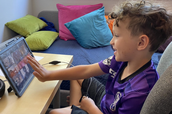 boy interacting with students on ipad