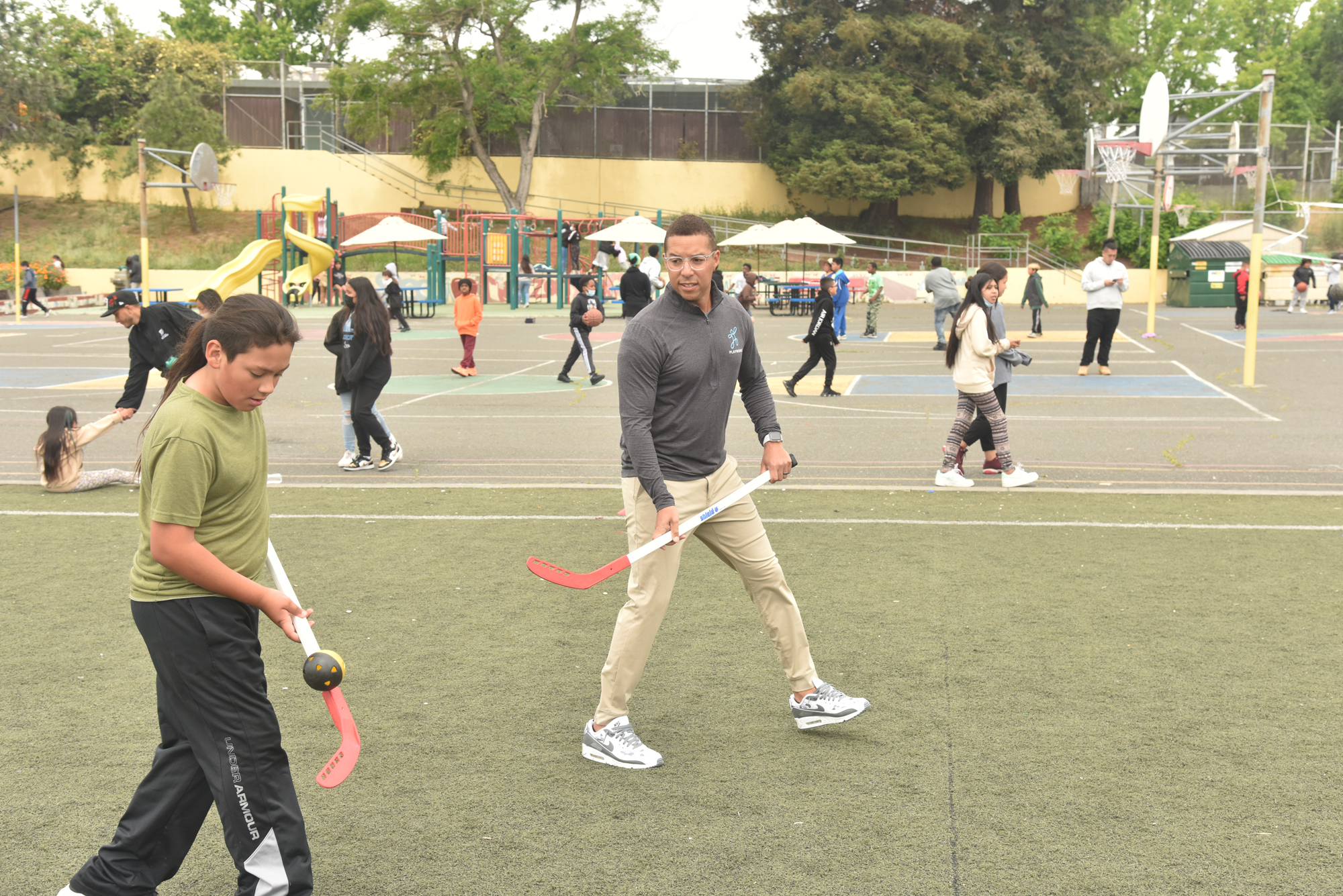adult and kids playing hockey
