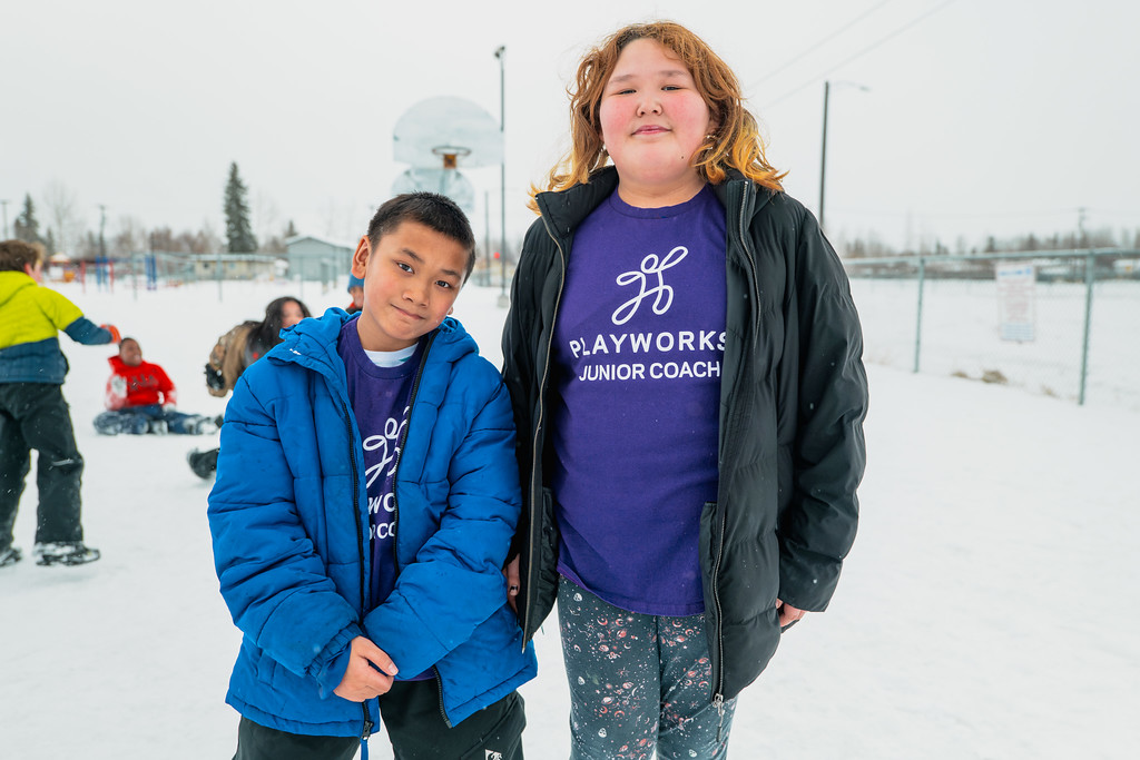 two students outside in snowy play yard