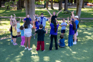 kids in circle with arms up